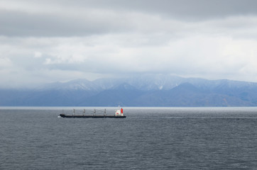 Small cargo ship sailing near Japanese island Hokkaido.