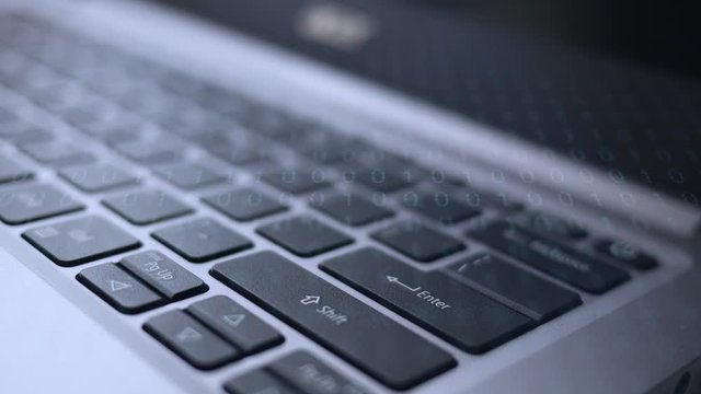 Finger dramatically presses the enter button on laptop with binary code overlay