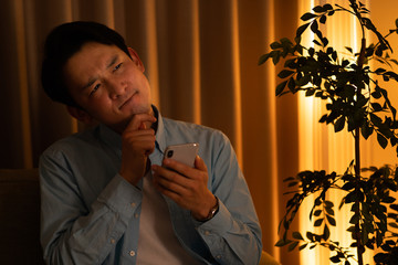 スマートフォンでコンテンツを見る男