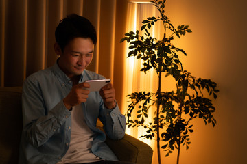スマートフォンでコンテンツを見る男