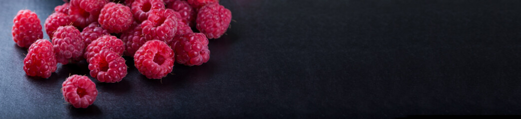 Fresh picked raspberries on black table