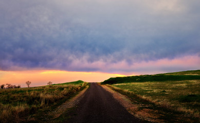 Rural dirt road in the countryside at sunset