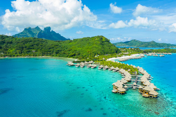 Travel vacation paradise aerial drone video with overwater bungalows luxury resort in coral reef lagoon ocean beach. Aerial of Mount Otemanu, Bora Bora, French Polynesia, Tahiti, South Pacific Ocean