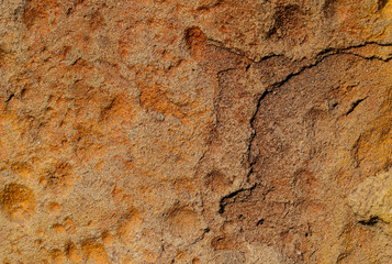 Background texture of orange stone with cracks and irregularities. Blur, close-up, top view, plenty of space for text, no one. Concept of design.