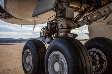 Obraz na płótnie Canvas Aviation: Huge airplane wheels with black tires on tarmac