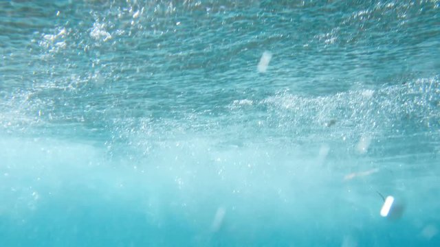 Beautiful underwater 4k video of rolling sea waves. View from the sea bottom