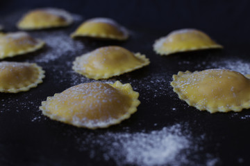 closeup homemade ravioli on a slate dish. Italian cuisine. Raw pasta