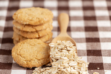 A pile of cookies and oats in spoon on the wooden table. Its are a nutrient-rich food associated with protein and fiber.
