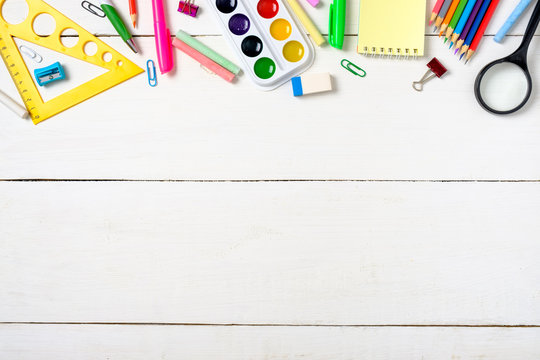 Back to school concept, colorful stationery supplies for teaching kids drawing on empty white wooden desk. Creative education setting, flat lay composition, top view, copy space. Kids desk top view.