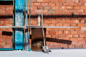 Old and used construction materials in front of a brick wall