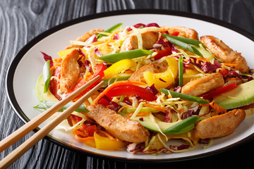 Balanced Asian coleslaw salad with chicken, avocado and vegetables close-up on a plate. horizontal
