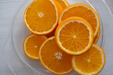 sliced orange lies in a glass transparent plate