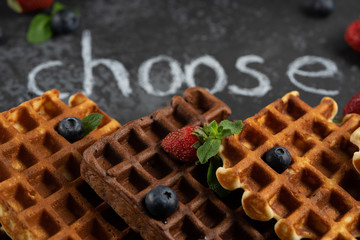 Chocolate and vanilla Belgian waffles with fresh berries on dark background. Sweet breakfast