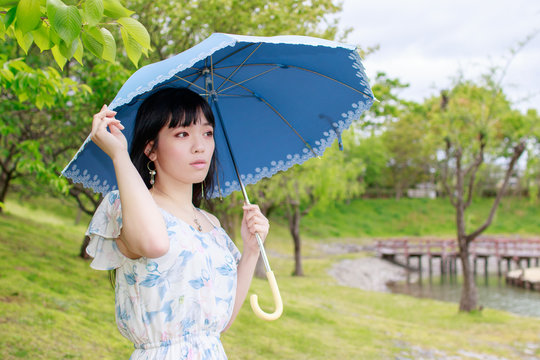 青い傘を差す女性