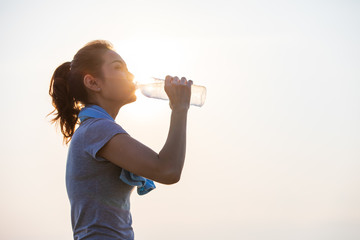 Woman drinking water after exercise.