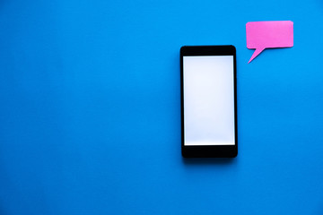 A black phone with a white screen next to a pink paper message icon is on a blue background.