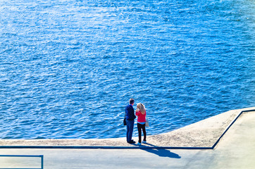 people walking along the promenade, Biking and scooters, watching the water flowing river or sea 