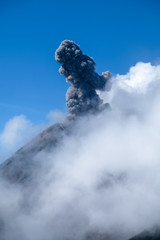 Erupting volcano in Guatemala against the blue sky