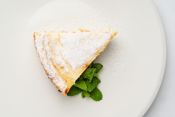 cheesecake with mint on white plate