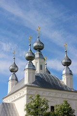 gold crosses on the white Church against the sky.