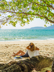 Woman enjoying her holidays on a transat at the tropical beach