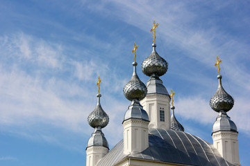 white Church with five domes with Golden crosses and blue sky