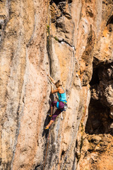 A girl climbs a rock.