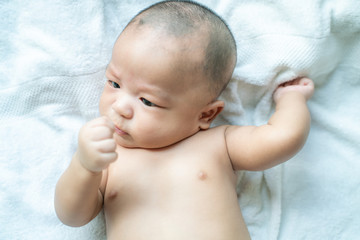 Infant baby boy lying on bed preparing to showing