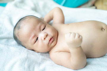 Infant baby boy lying on bed preparing to showing