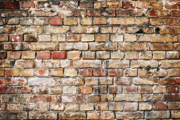 Old damaged brick wall with shabby plaster.