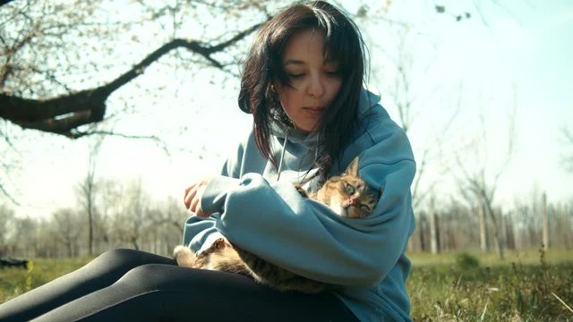 Woman in meadow grass playing with cat pet. Shot on RED slow motion footage