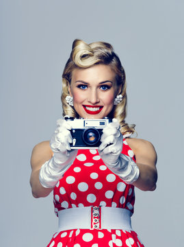 woman, with no-name camera, taking picture, dressed in pin-up style