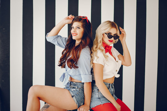 Glamour girls in a studio. Pretty brunette in a pin up clothes. Lady in a sunglasses