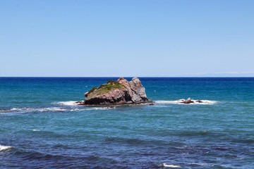 Wonderful light and dark sea, rock in the centre in Akamas peninsula national park, Cyprus. Aphrodite bath. Blue sky and sea. Murmur sea. Foam around rock.