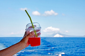 a glass of juice on the sea