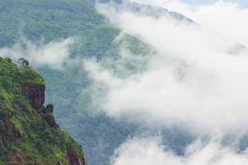 Obraz premium rock overgrown jungles and cloud landscape