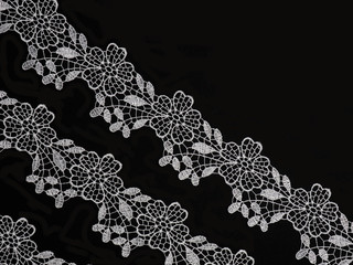 White laces on a black background diagonally in three row