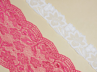 Red and white laces on a beige background diagonally in two row