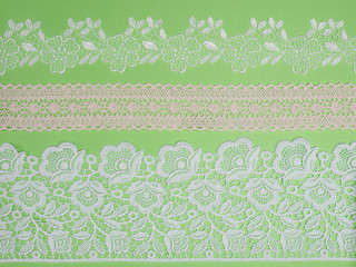 White laces on a green background horizontally in three row
