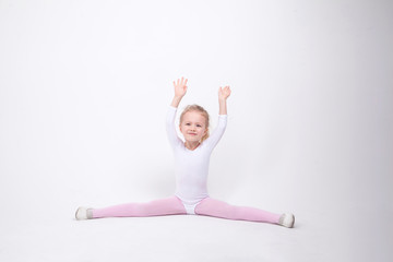 Smiling Little girl gymnast on a white background