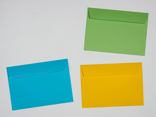 Green, blue, yellow envelopes on a white background
