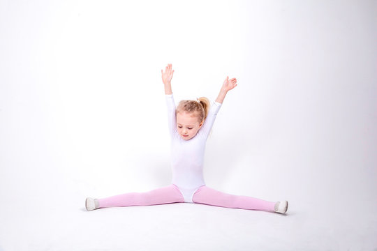 Smiling Little girl gymnast on a white background