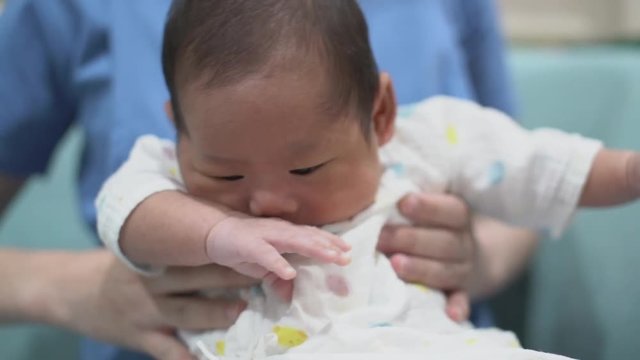 cute asian infant baby boy hungry cry  in mom arm with love and careful