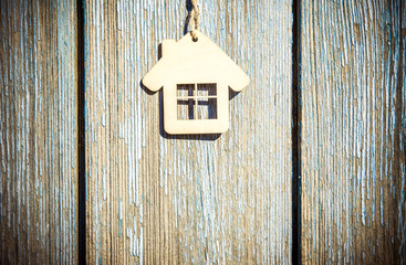 The symbol of the house hangs on a blue wooden background 