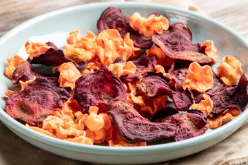 Close-up turquoise plate with chips from carrot and beetroot. 