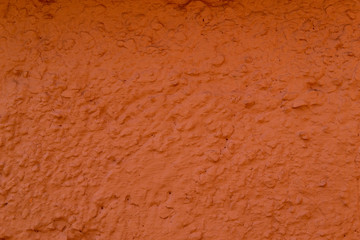 The texture of the concrete wall is coral color. A raw plaster wall background