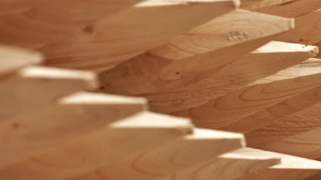 Round wooden posts after wood processing. Wooden sharpened logs on shelves