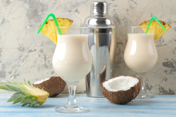 Cocktail Pina Colada. Pina Colada refreshing summer alcoholic cocktail with coconut milk and pineapple juice nearby. summer drink. cocktail preparation. on a light background and on a blue table.