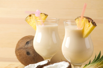 Cocktail Pina Colada. Pina Colada refreshing summer alcoholic cocktail with coconut milk and pineapple juice nearby. summer drink. cocktail preparation. on natural wooden background