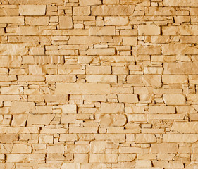 Light brown stone wall with rough surface texture background.